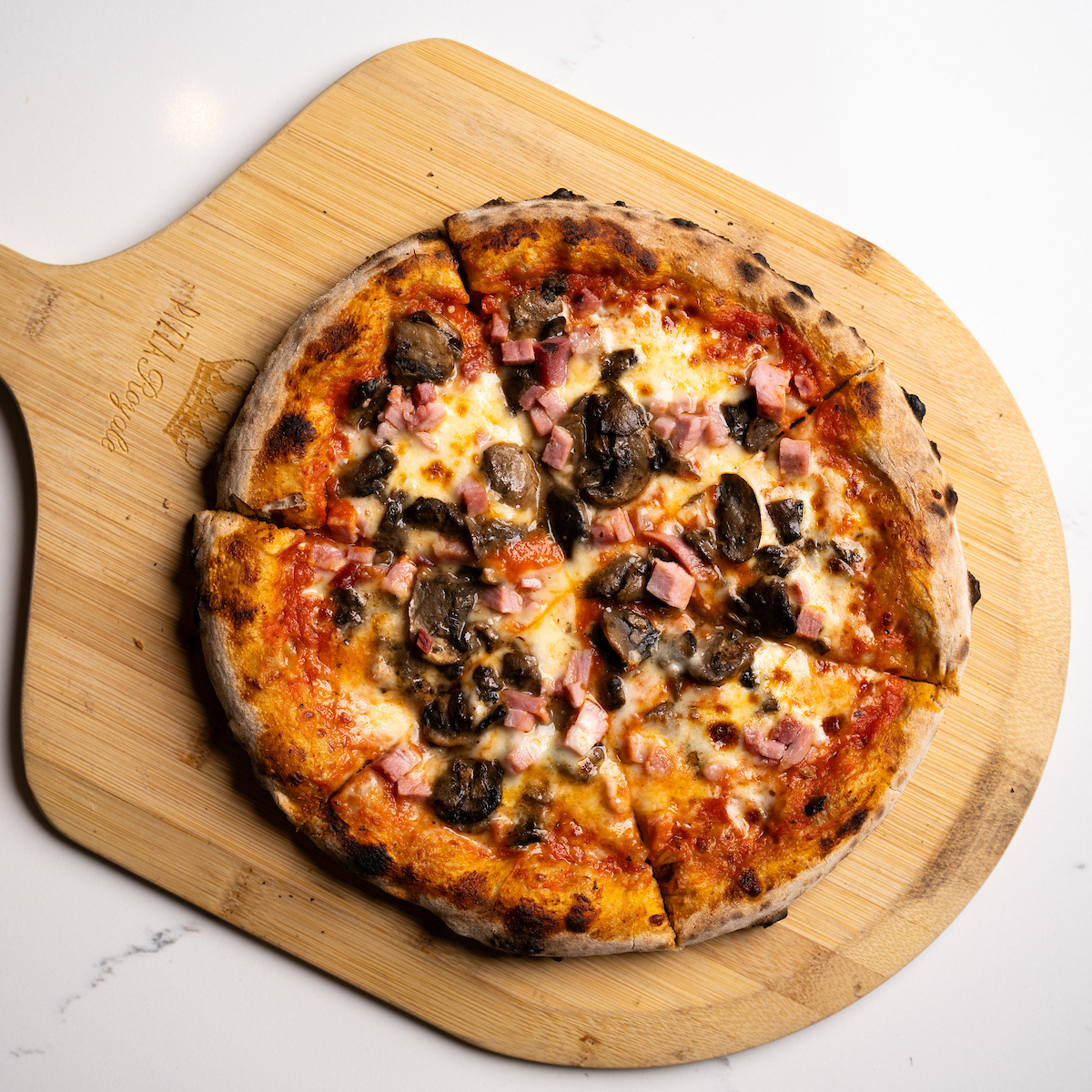 Oven-fired, hand-tossed pizza with Marksbury Farm ham and cremini mushrooms, made with carefully sourced, quality ingredients